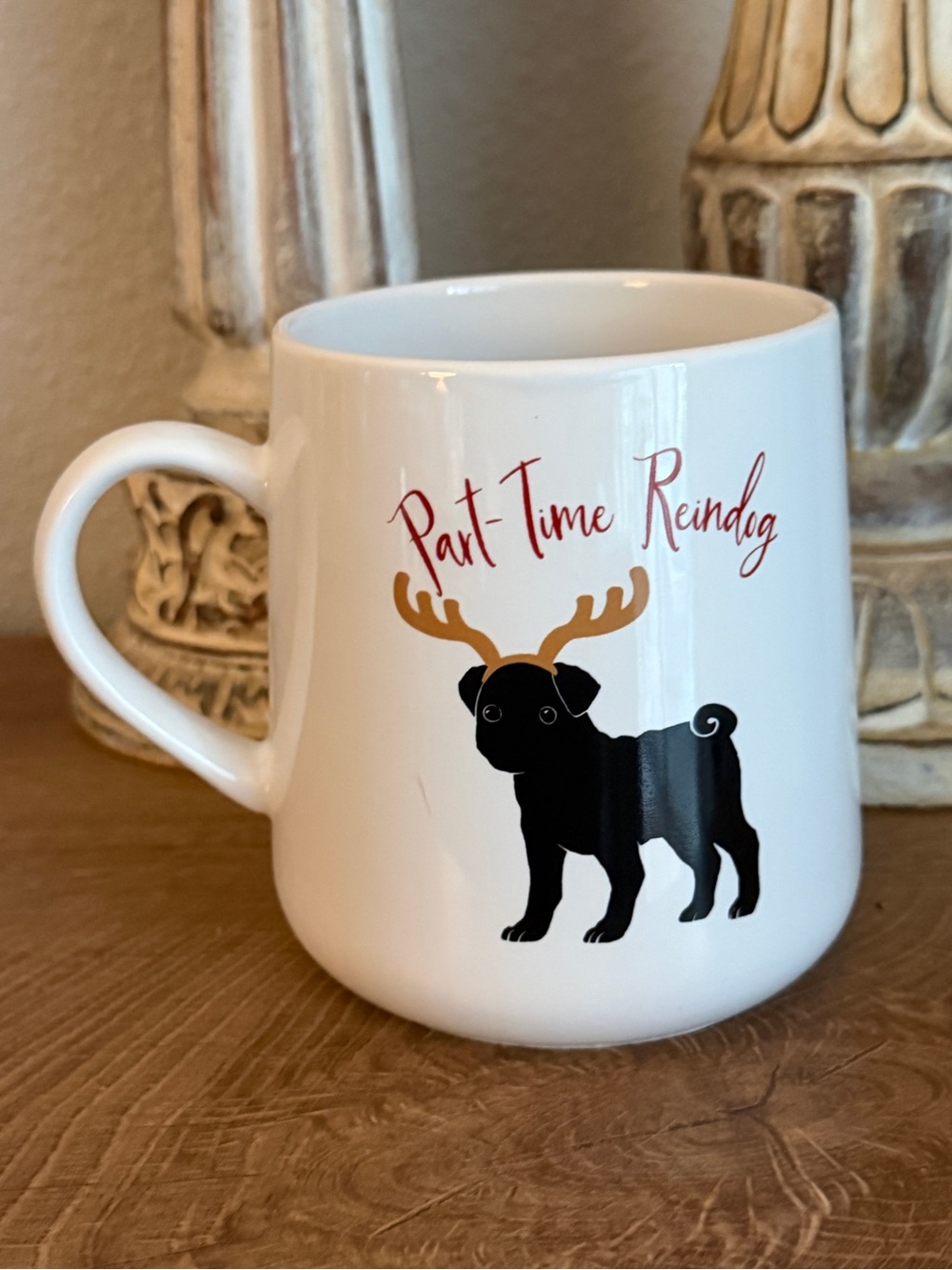 Oversized black pug with antlers holiday coffee mug